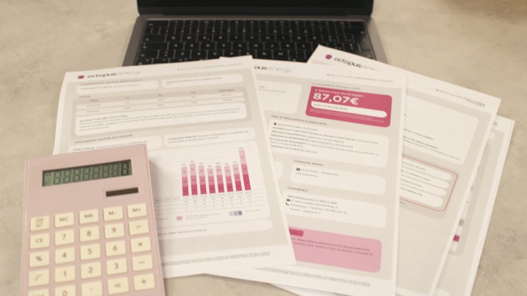 Bills, calculator, and a laptop: financial tasks underway