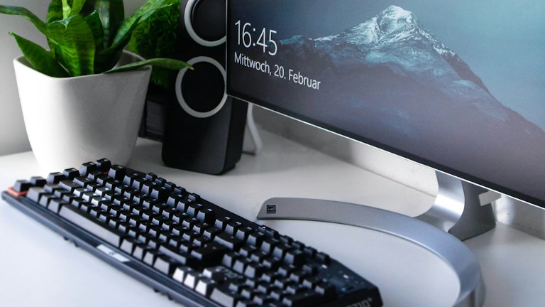 black Logitech G710+ wireless keyboard and wireless mouse near gray flat screen computer monitor on table