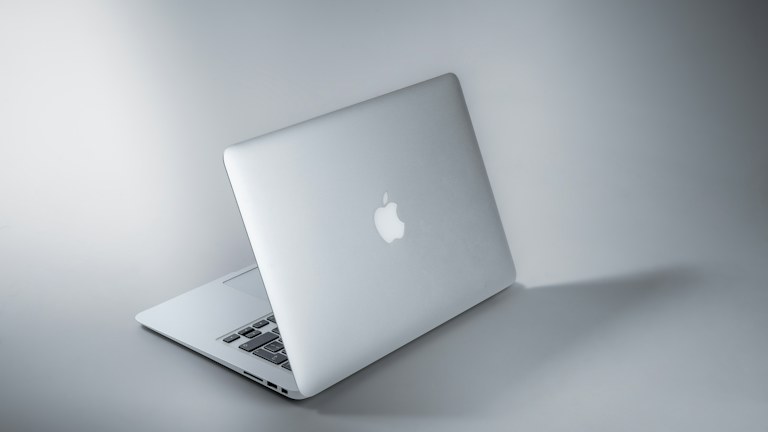 silver macbook on white table