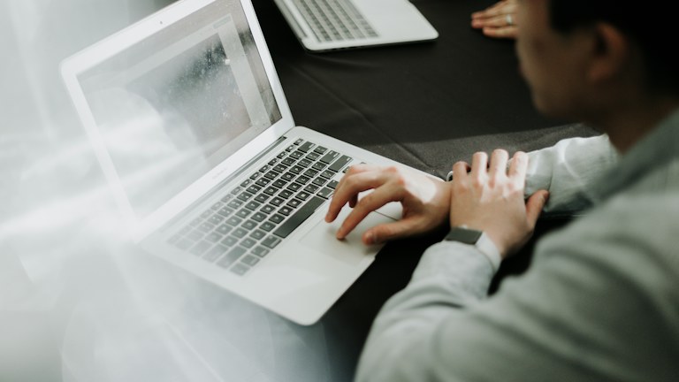 a man sitting in front of a laptop computer