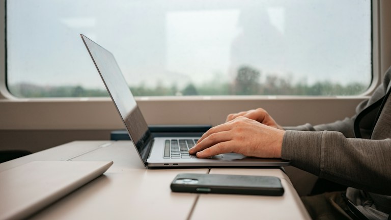 a man sitting at a desk using a laptop computer